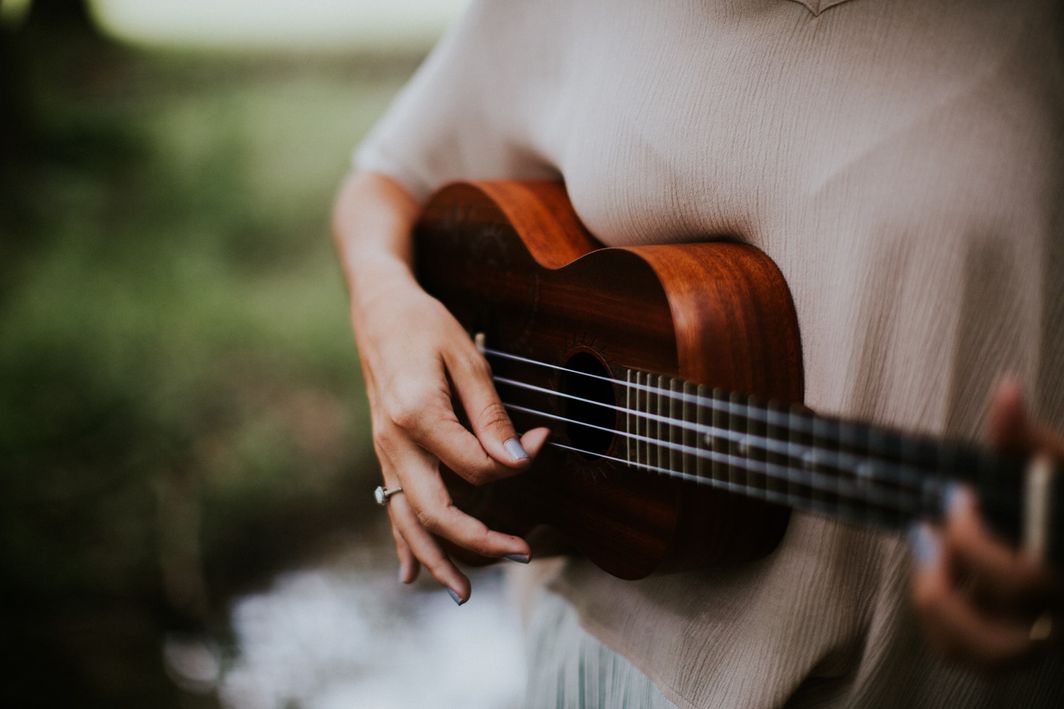 women plays on ukulele